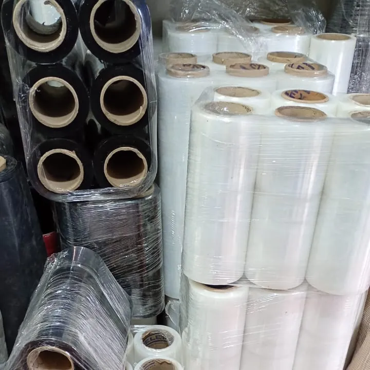 Rollos de película stretch, transparente y negra, apilados en bodega.